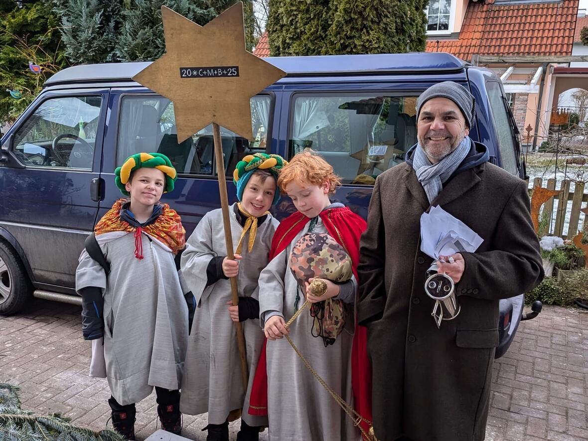Sternsinger unterwegs mit Pfarrer De Blasi im Westen der Stadt